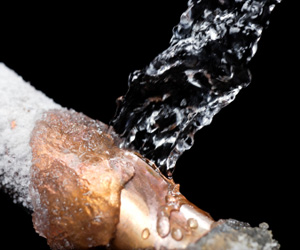 Water pouring onto a frozen copper pipe.