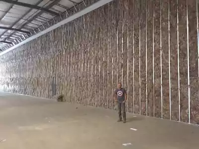 Worker standing in a large insulated warehouse.