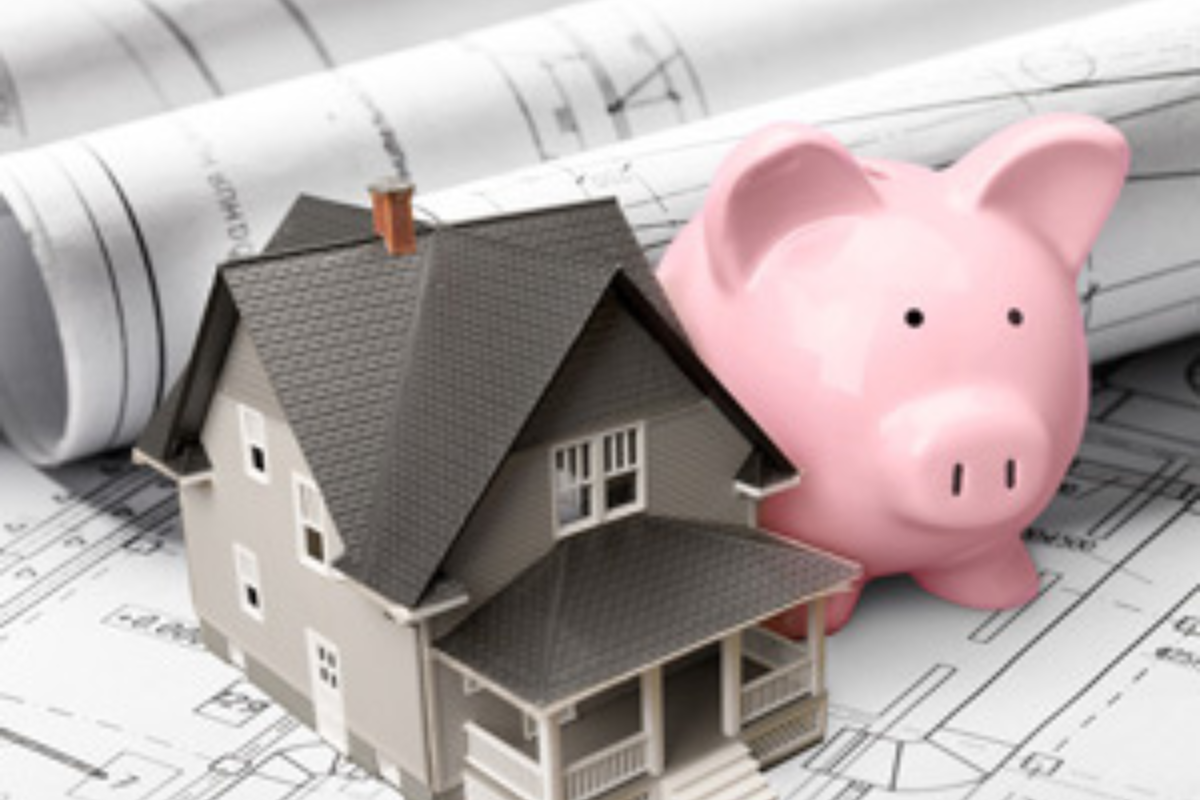 House with architectural plans and piggy bank