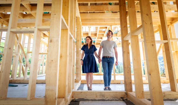 Couple walking through new home under construction