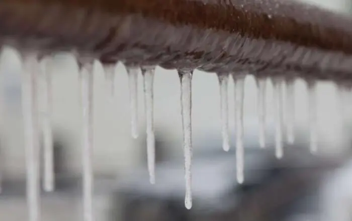 Close-up of frozen icicles on roof eaves