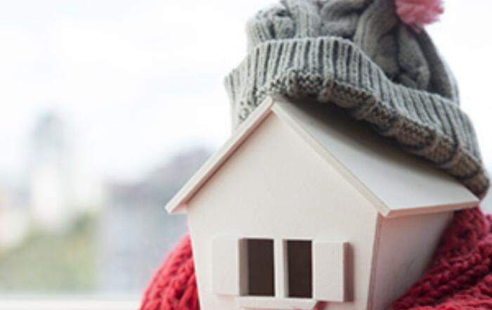 Small house wrapped in scarf (symbolizing energy efficiency)