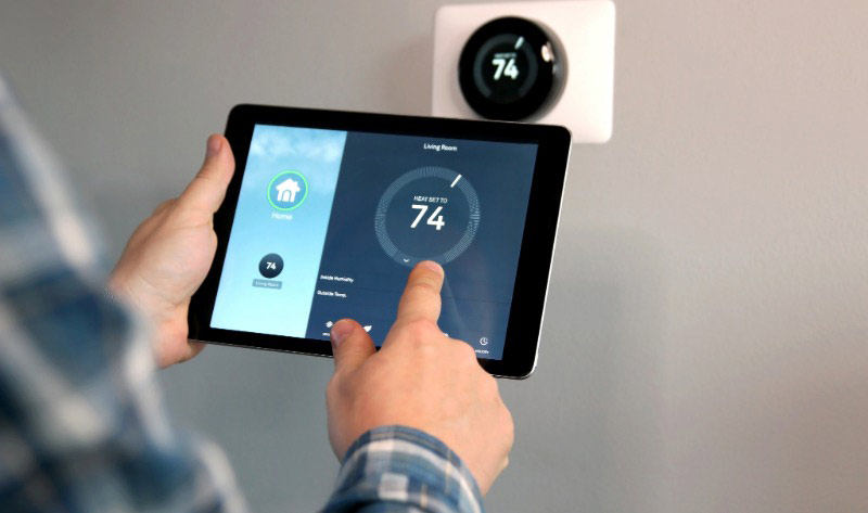 Smart thermostat on a living room wall showing 21°C, helping homeowners save energy during winter.